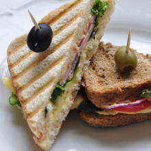 Zapečený toast s hummusom, šunkou, syrom, rajčinami, šalátom a cibuľou