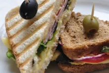 Zapečený toast s hummusom, šunkou, syrom, rajčinami, šalátom a cibuľou